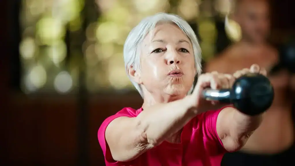 Older woman doing weight training Eccles to help her strength and longevity 