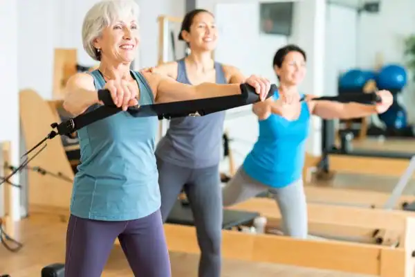 Toning Arms After 60: Empowering Womens Fitness Through Effective Weight Training 2 older woman doing weight training Eccles and resistance in the gym to tone upper arms