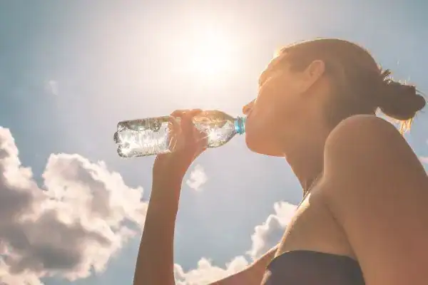 Hydration: The Secret Ingredient for a Toned Stomach and Enhanced Fitness 3 Image of woman drinking water to hydrate Eccles after run.